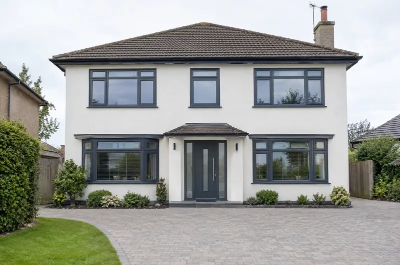 Detached house front with every window and the front door replaced in anthracite grey